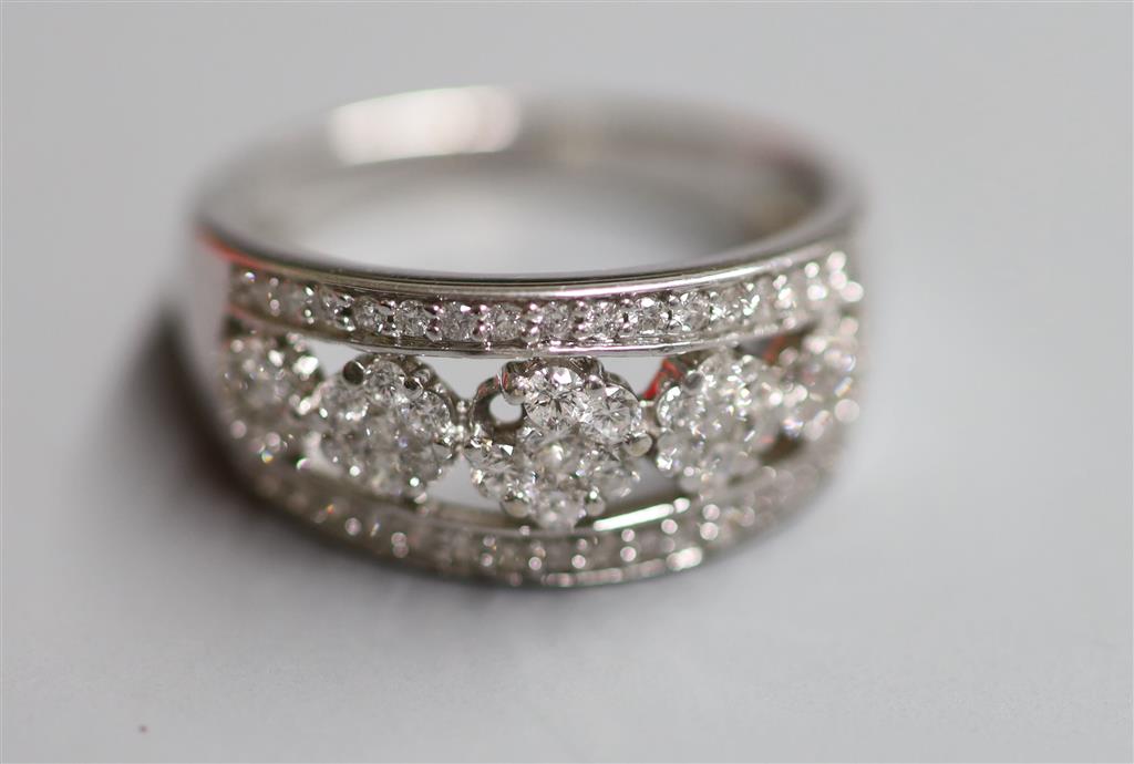 A modern 18ct white gold and graduated quintuple flower head cluster half hoop ring with diamond set border, size Q, gross 5.7 grams